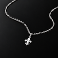 Srebrna ogrlica s ravnim privjeskom fleur-de-lis na crnoj podlozi